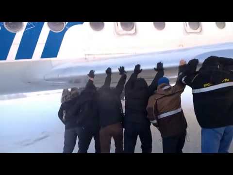 Los pasajeros empujan su avión en Siberia para soltarlo del hielo y poder despegar