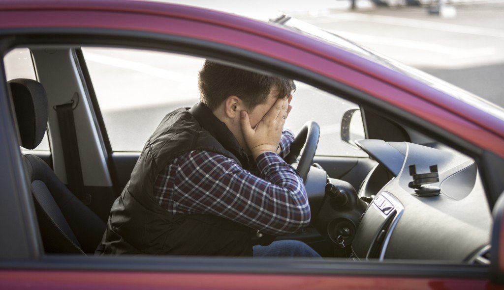 Closeup portrait of shocked male driver closing face with hands